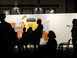 Personen stehen in einer Kunstaustellung.